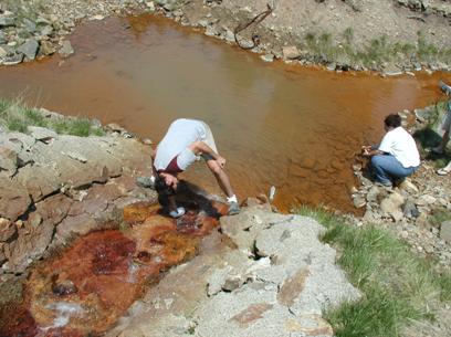 Photograph showing people collecting samples from mining impacted stream, central Colorado.