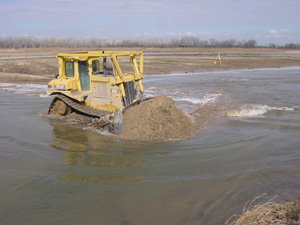 Bulldozer pushing sediment into Platte River
